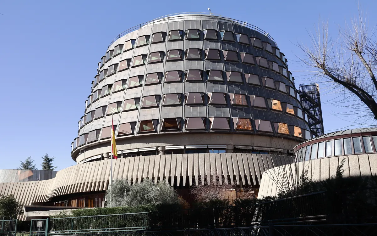 Edificio de forma circular del Tribunal Constitucional en Madrid con ventanales y bandera de España