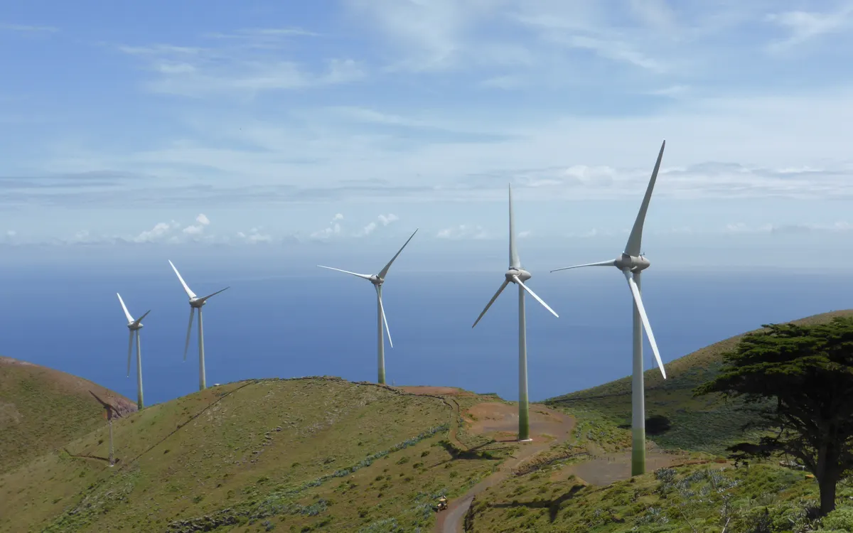 Aerogeneradores sobre una colina verde junto al mar en la isla de El Hierro