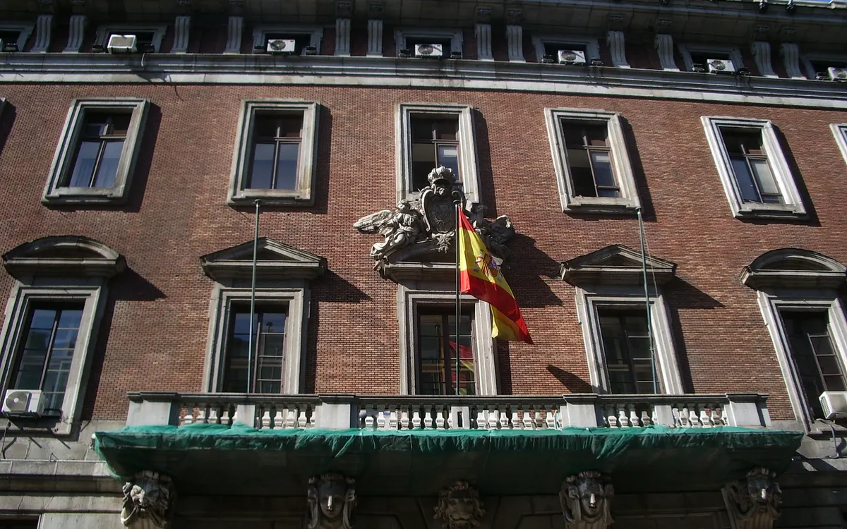 Fachada de ladrillo del Ministerio de Hacienda en Madrid con la bandera de España