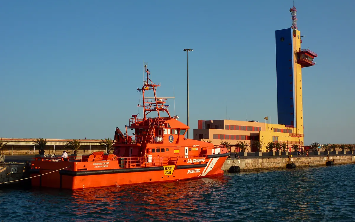 Embarcación naranja de Salvamento Marítimo atracada en el puerto de Almería al atardecer