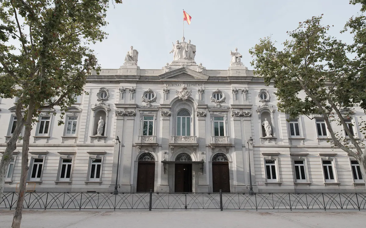 Fachada principal del Tribunal Supremo en Madrid con la bandera y árboles a los lados