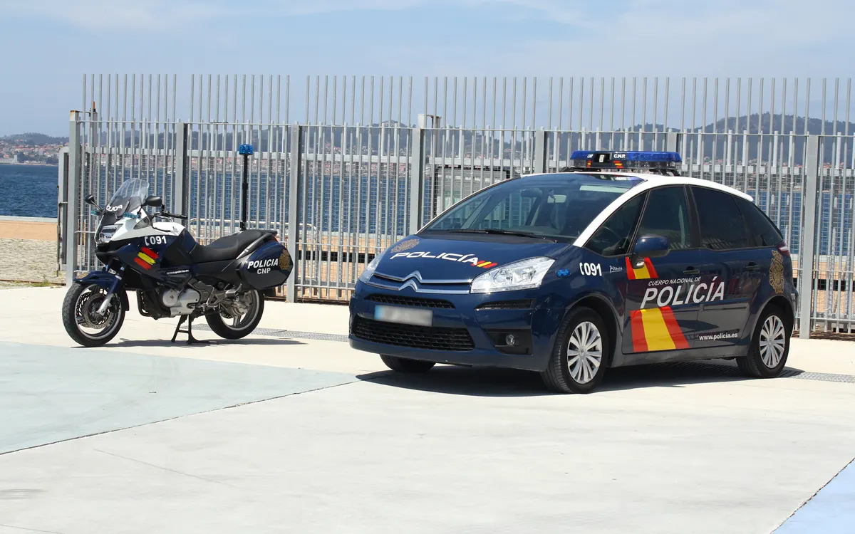 Coche patrulla y motocicleta de la Policía Nacional aparcados junto al mar en Vigo